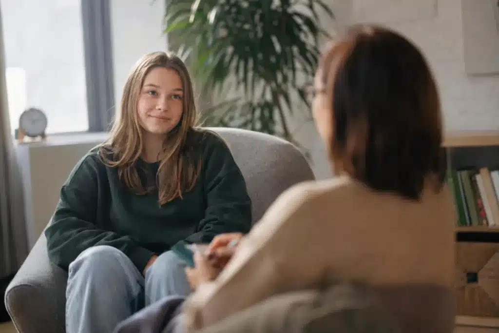 Teen girl meeting with a therapist in a calm, sunny office