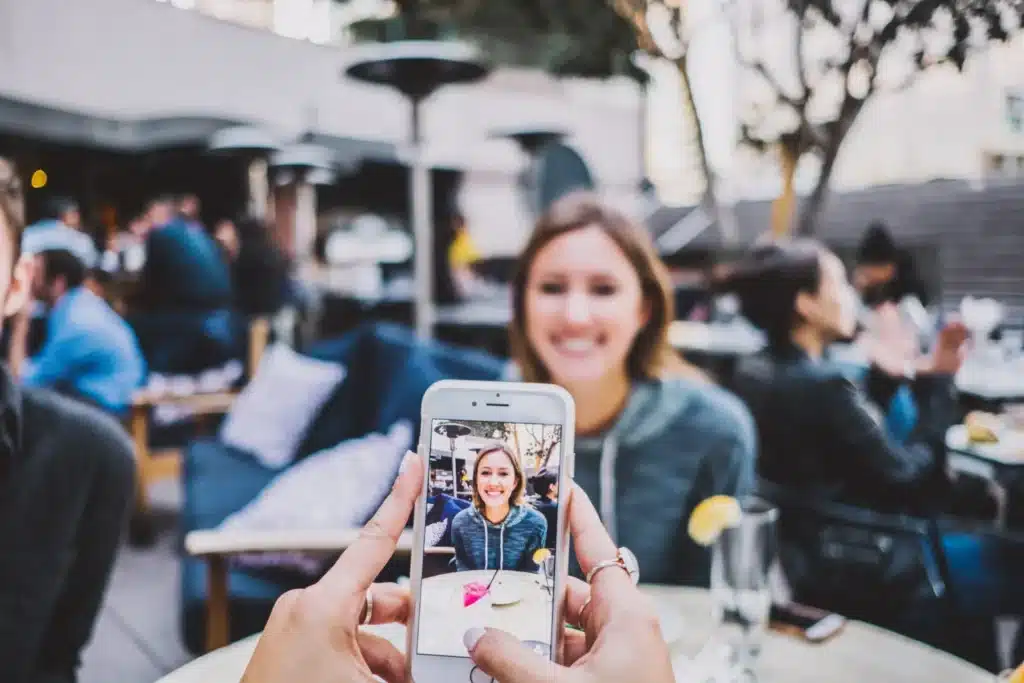 Woman at a cafe seen through a friend's phone, a picture of comparison near Orland Park, IL